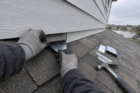 Step flashing being fitted where a first-floor roof meets a second-story fiber-cement wall